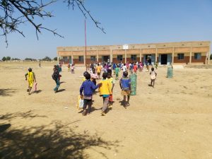 Élèves marchant vers un bâtiment scolaire à Ouaregou, Garango. Salles de classe financées par le FDCI.